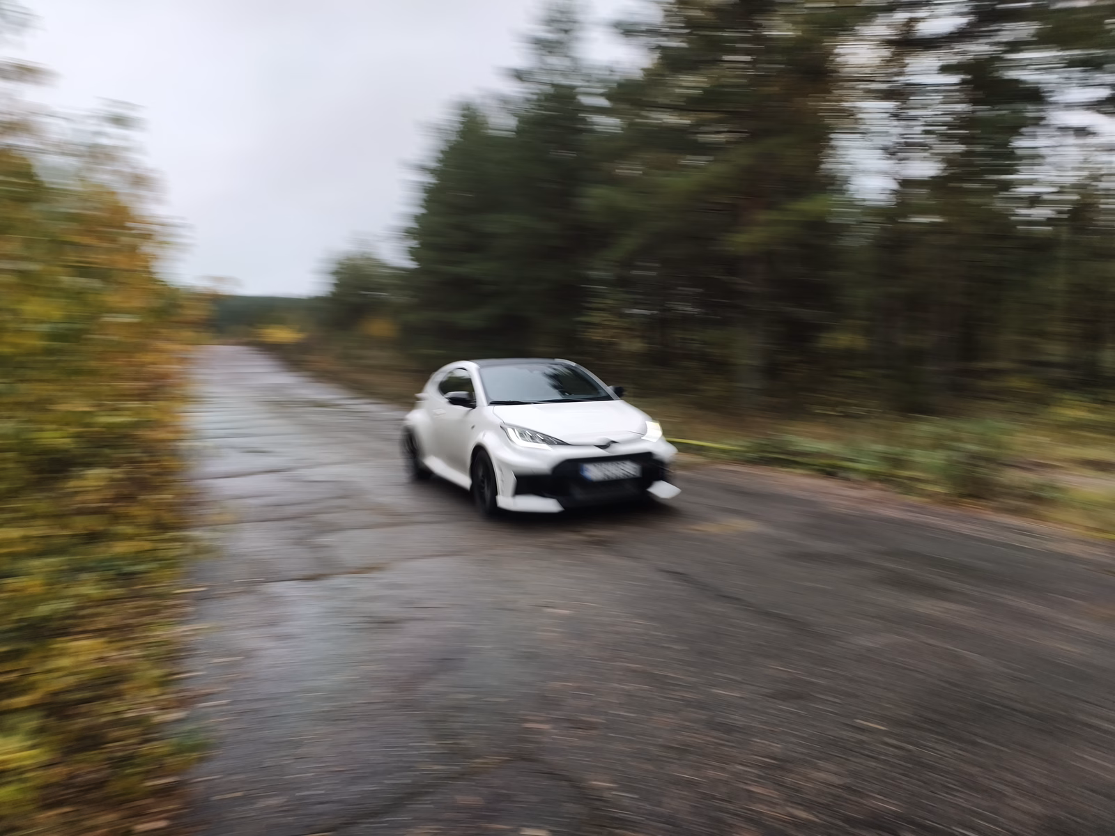 Baltas sportinis automobilis trasoje.